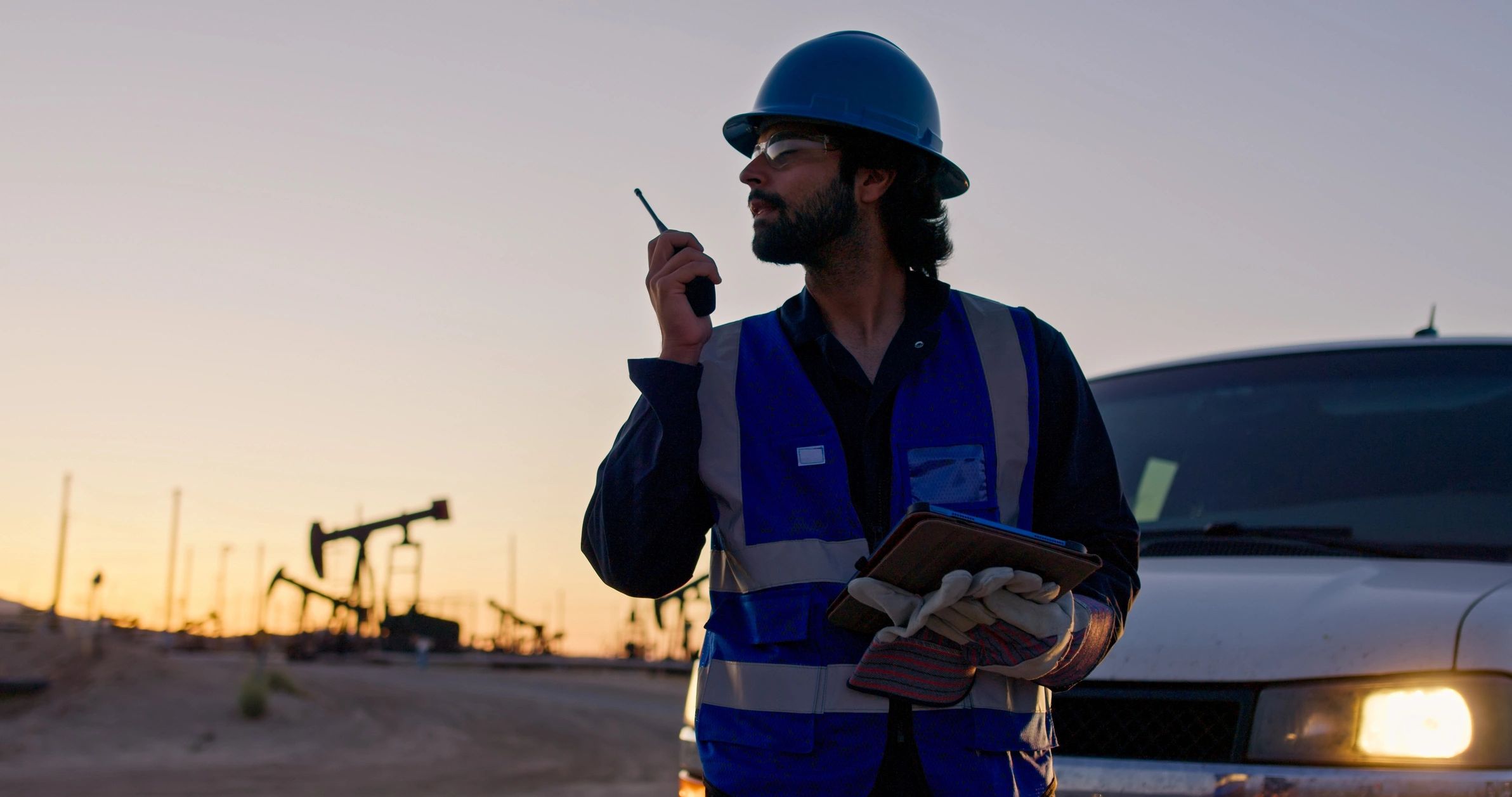 Engineer communicating at an energy site at sunset